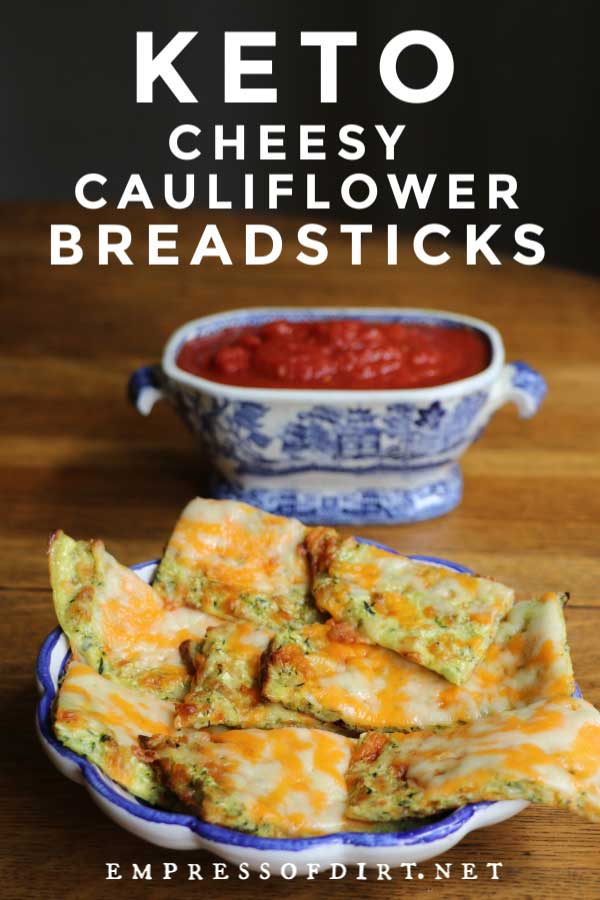 Cheesy keto breadsticks with a bowl of tomato dipping sauce.