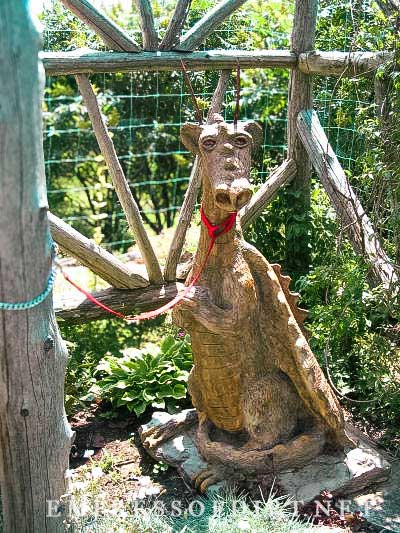 Carved wooden baby dragon in garden