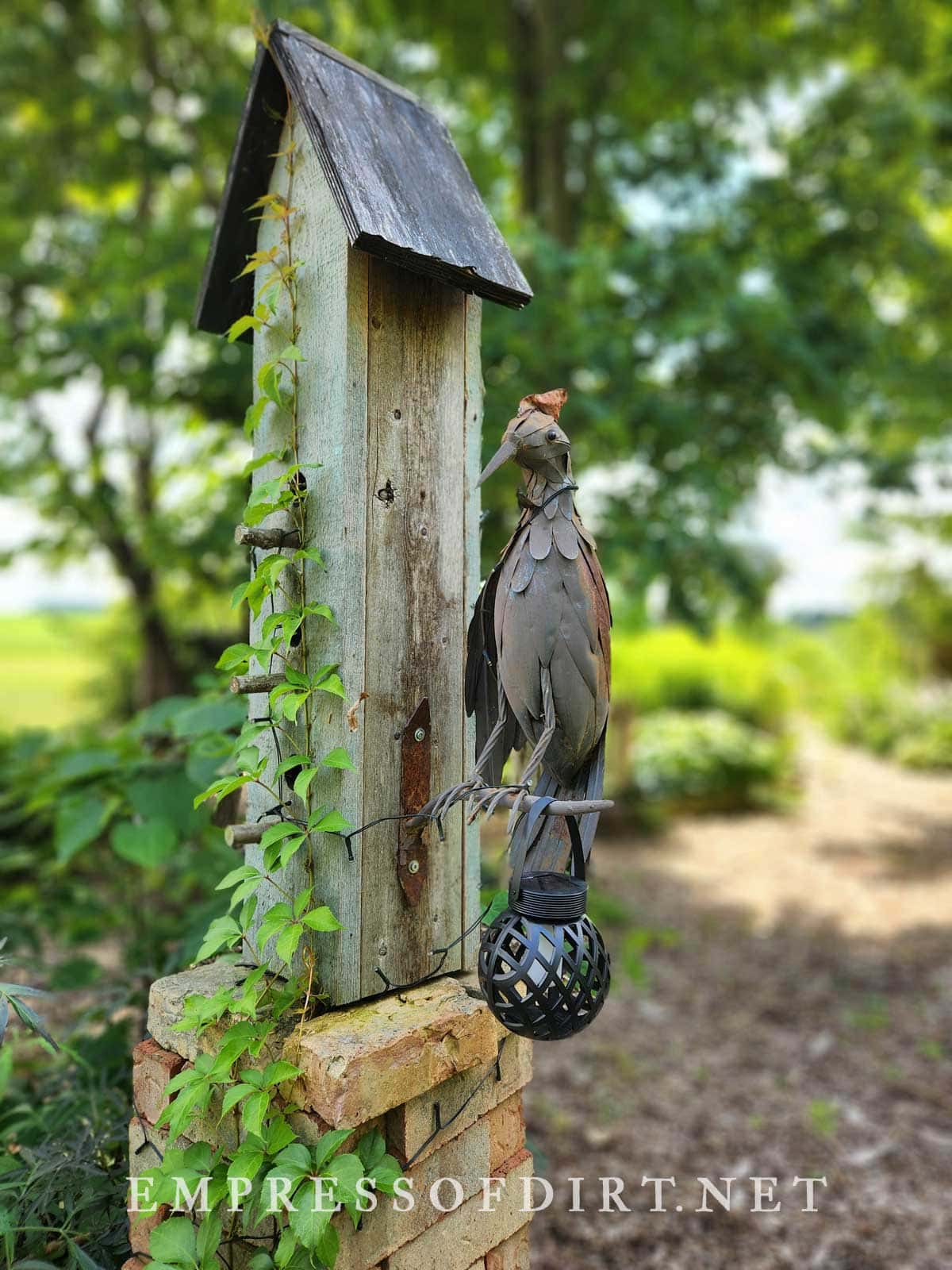 Bird art perched at tall birdhouse