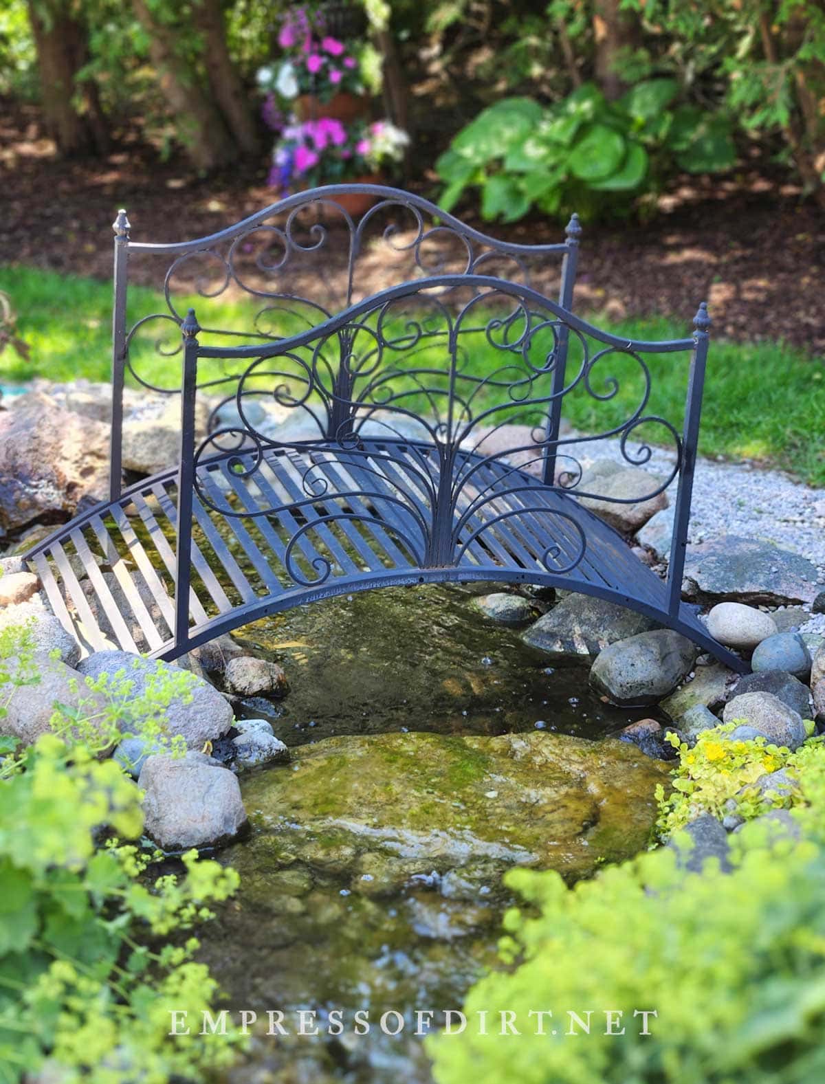 Black bridge over garden pond