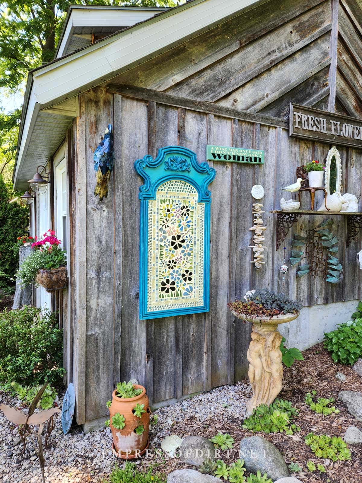 Lovely collection of garden art, plants, and collections on rustic shed walls