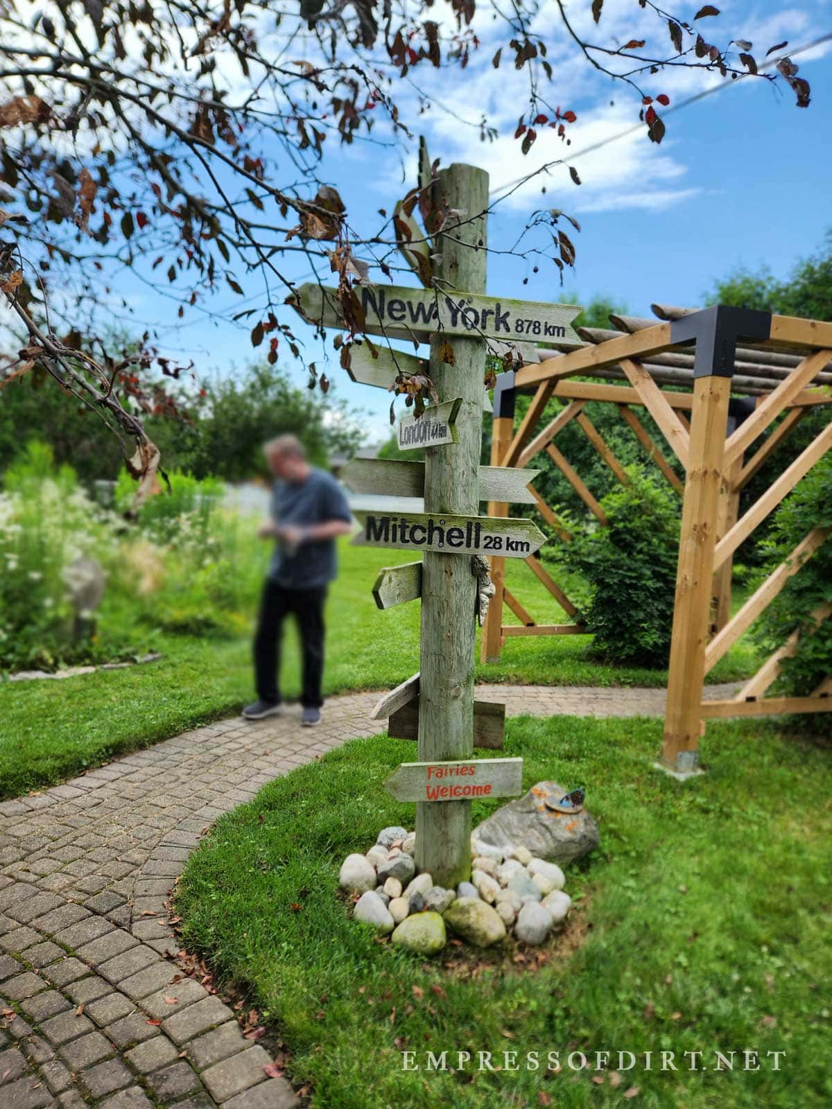 Old wooden post displaying name signs for different parts of the world.