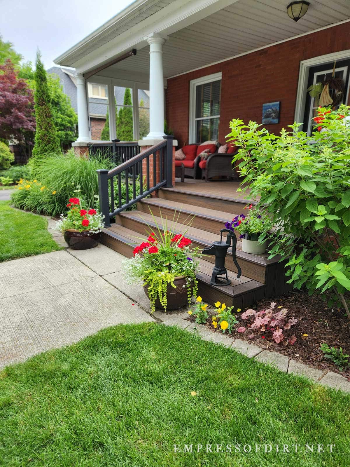 Front porch with flowers pots on steps.