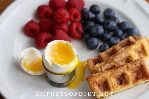 Soft boiled egg, berries, and chaffle slices.