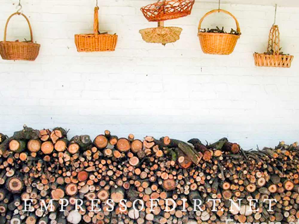 Neatly-stacked wood pile and wicker baskets.
