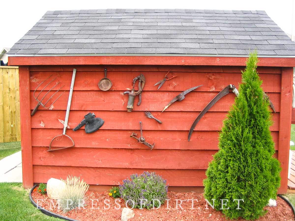 Wood-stained shed with old tools as wall art.